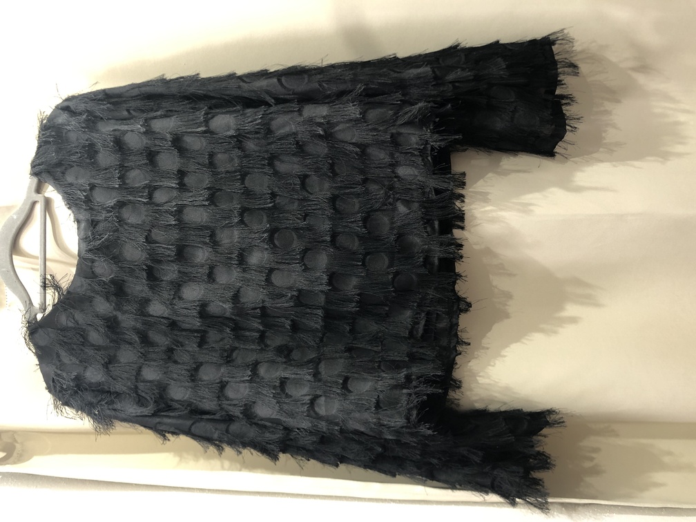 Blusa negra con cuello a la caja de flecos. Talla unica. Precio 25E