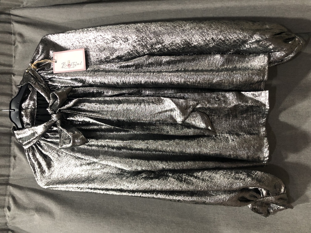 Camisa tonos plateados con lazo en le cuello manga larga. Talla unica. Precio 40E